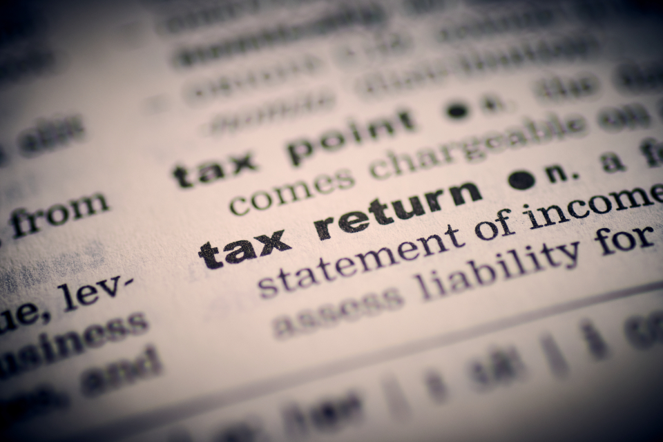 Tax documents, calculator and laptop representing digital nomad tax planning