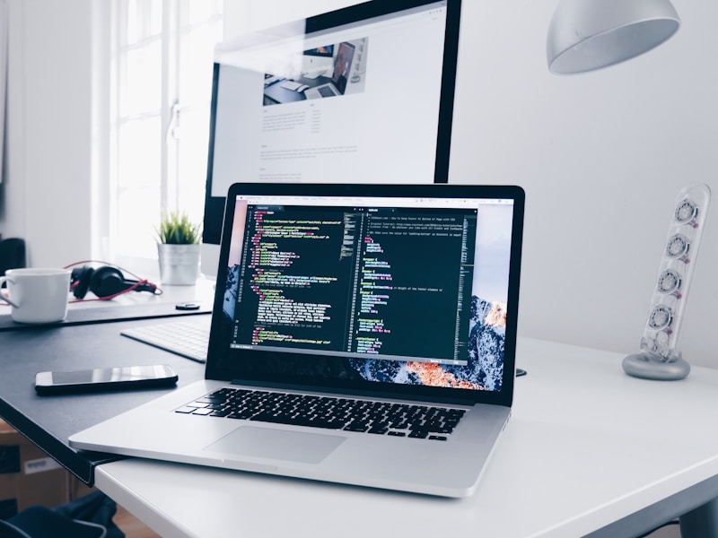 Laptop with code on screen and coffee cup representing remote work reality